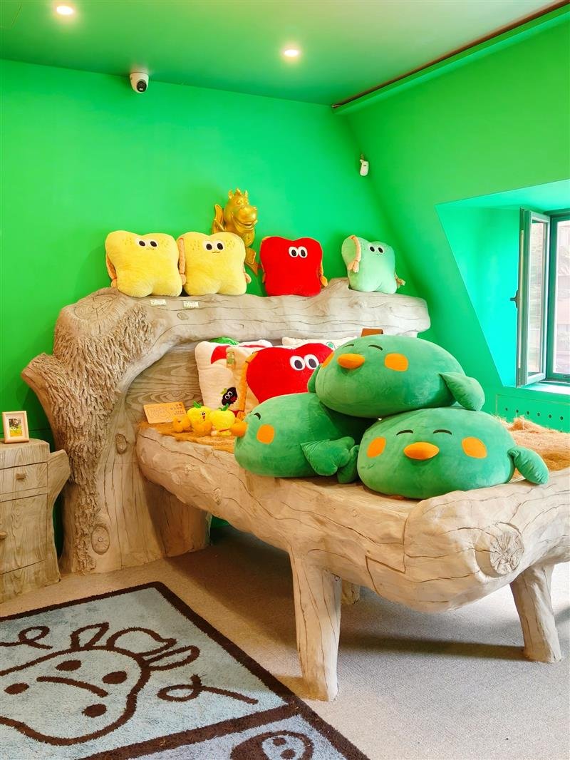 Cama infantil de madeira com pelúcias coloridas em quarto verde claro