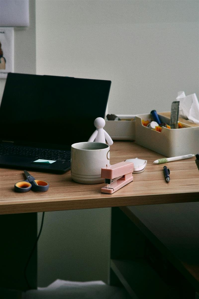 Mesa de trabalho de madeira organizada com notebook e material de escritório