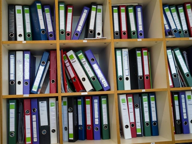 Prateleira com pastas e fichários coloridos organizados