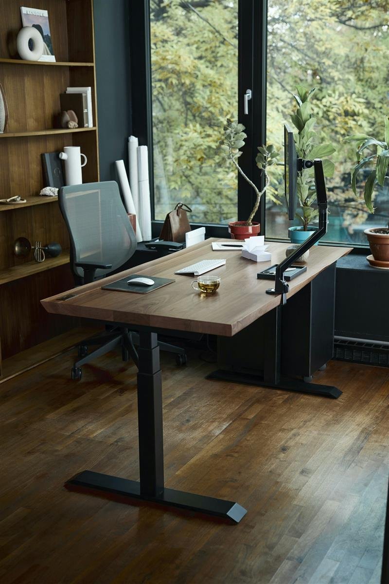 Mesa de home office organizada perto de uma janela