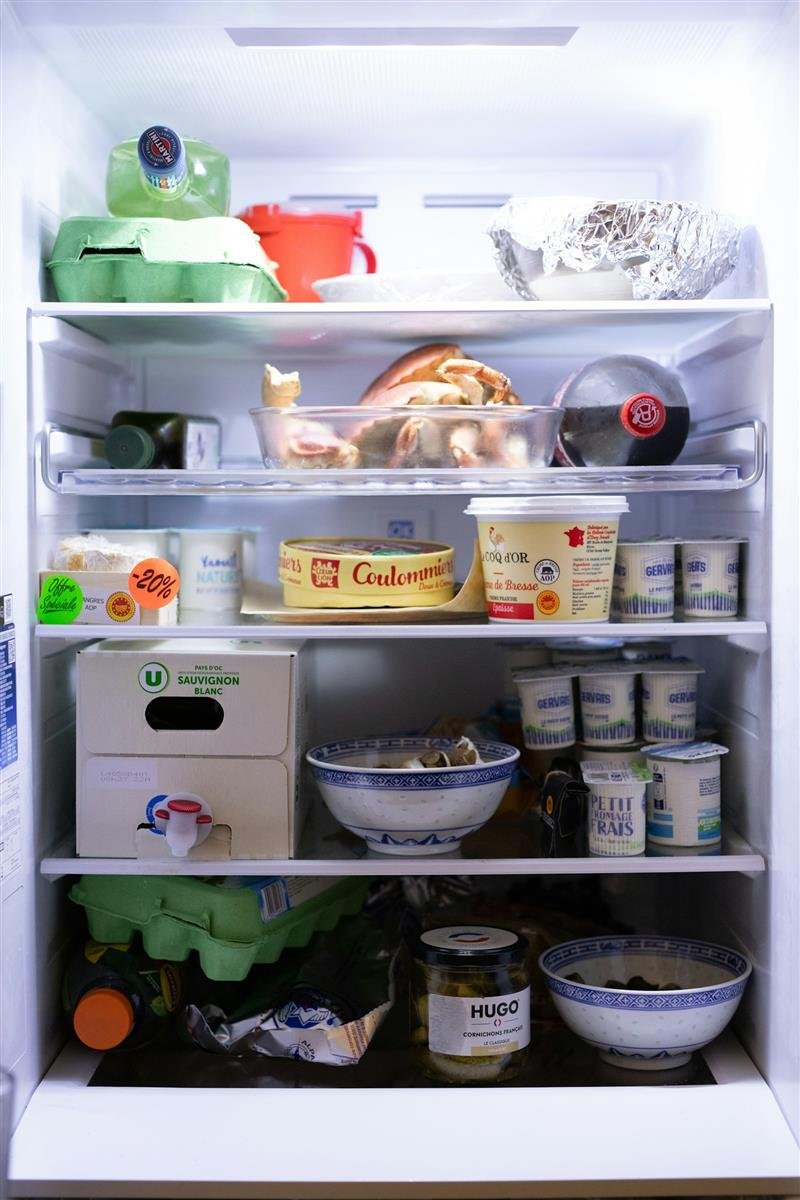 Geladeira organizada com potes e alimentos visíveis
