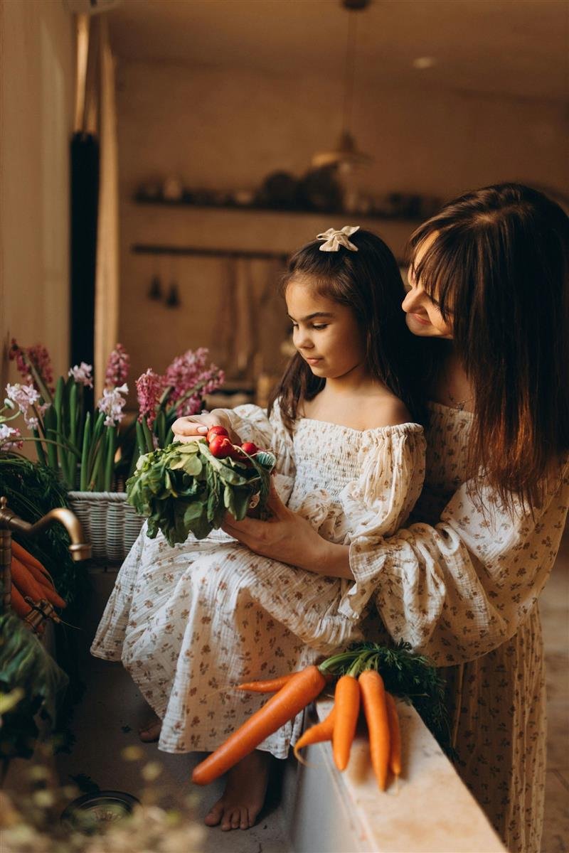 Mãe e filha preparando legumes juntas na cozinha