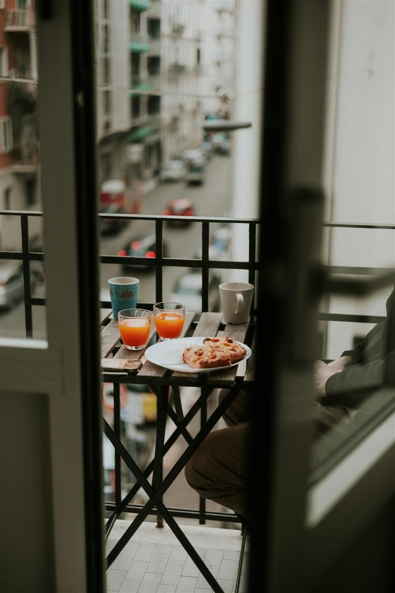 Café da manhã servido numa varanda com vista para a rua da cidade
